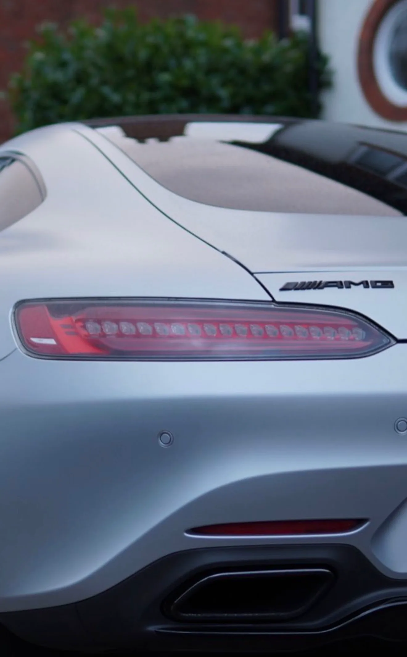 The rear quarter of a coated silver Mercedes-AMG GT, paint still crisp