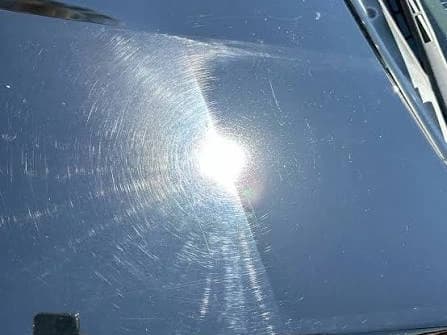 Direct sun on one panel, corrected on one side of the seam and untouched on the other — the corrected half holds a tighter, deeper reflection