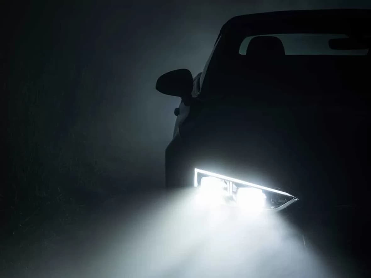 A headlight throwing a hard, defined beam into the dark