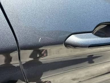 A single light scratch on an otherwise flawless grey door, beside the handle